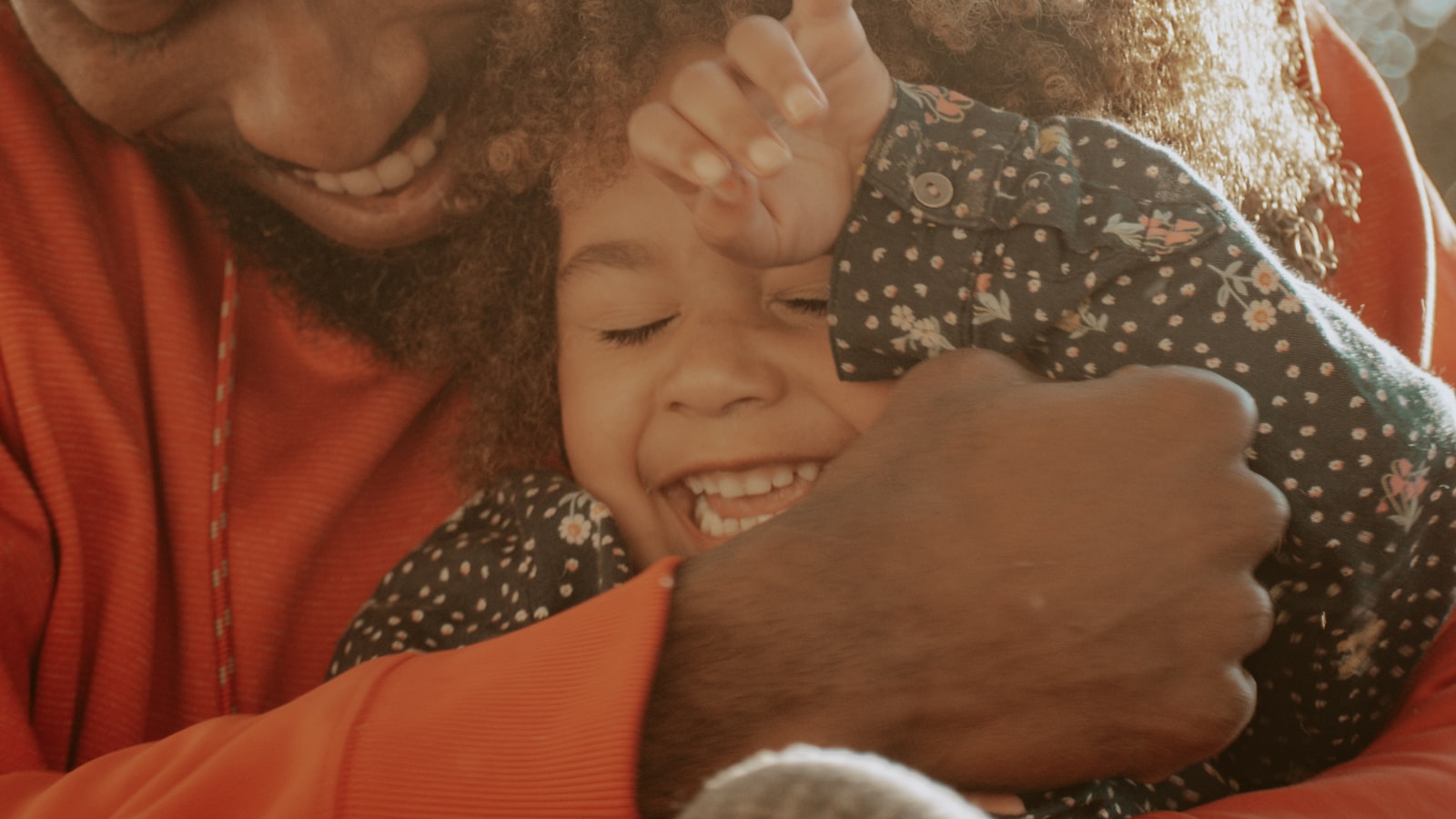 A father hugging his laughing young daughter