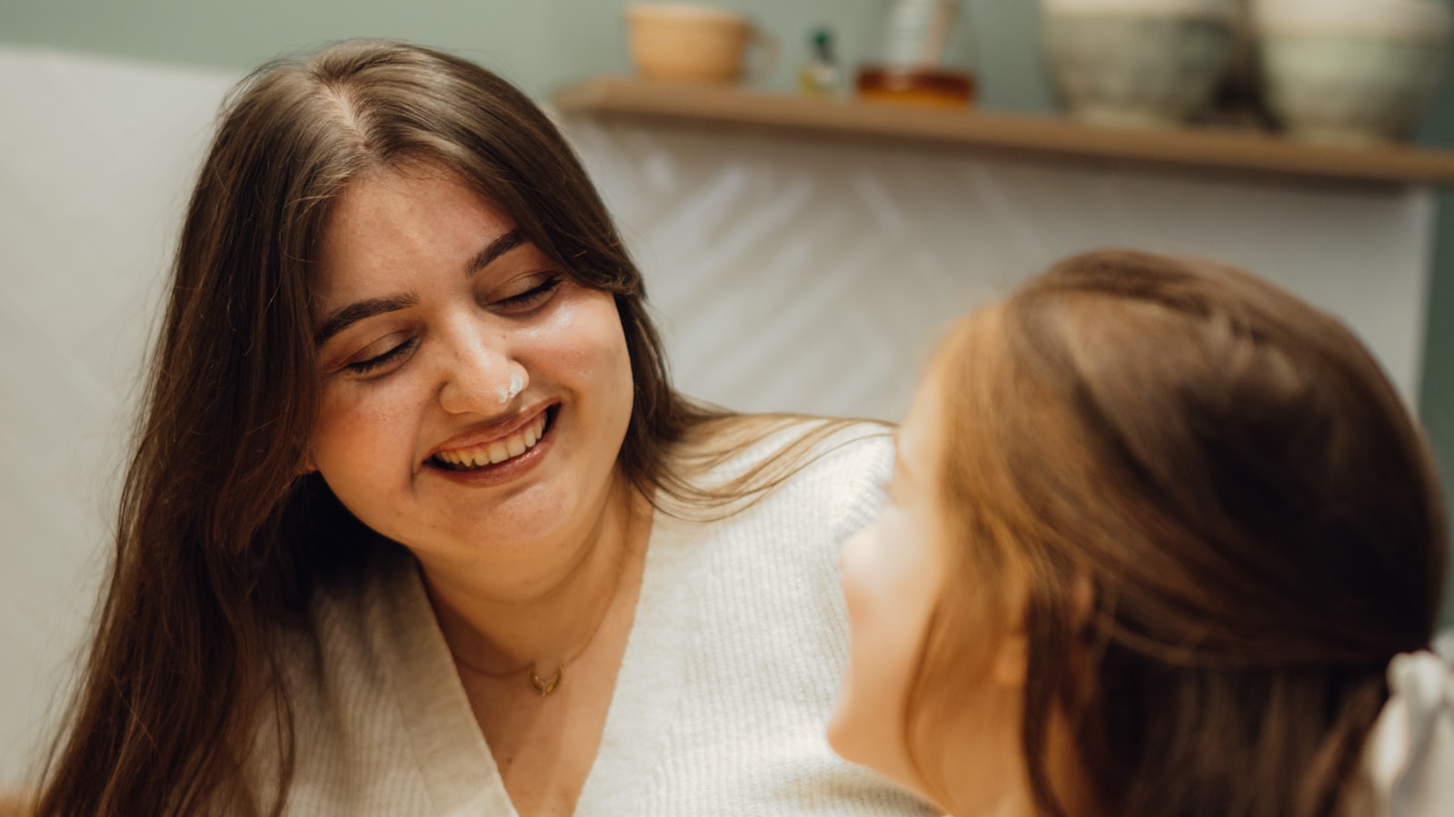A mother and her young daughter baking together at home